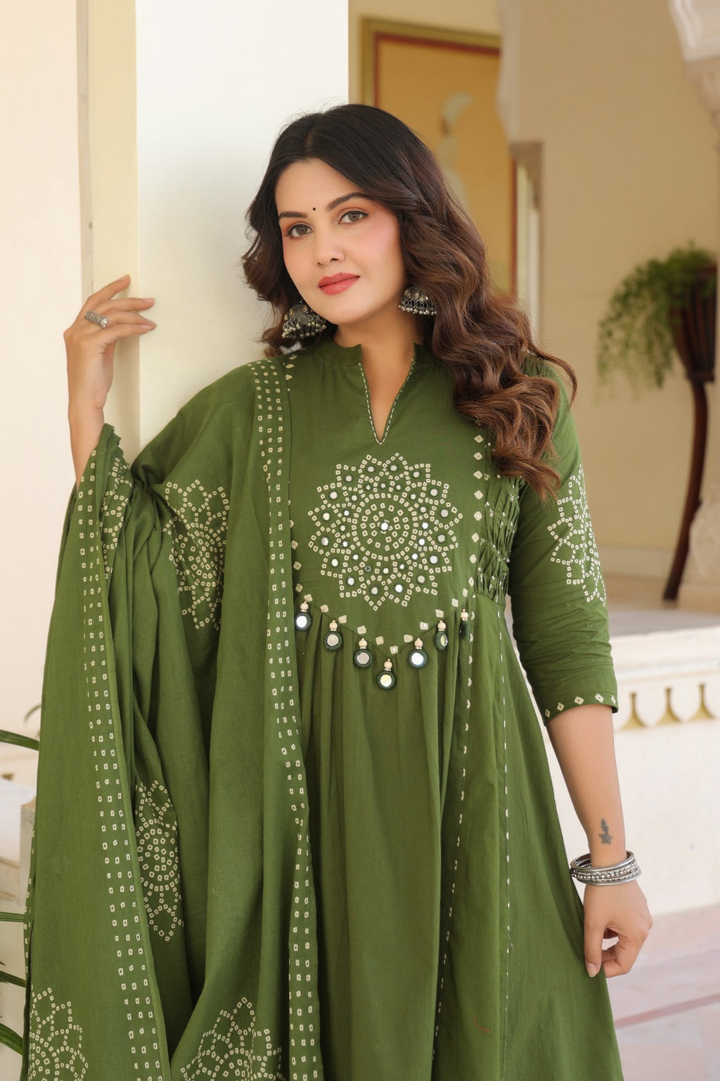 Wine Anarkali bandhani suit – close-up portrait showing mandala mirror work chest embroidery and mirror tassels